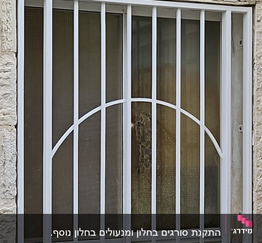 סורגי מתכת לבנים על חלון זכוכית